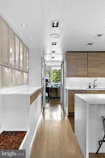 a view of living room with stainless steel appliances kitchen island a table and chairs