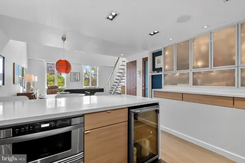a living room with furniture kitchen view and a wooden floor