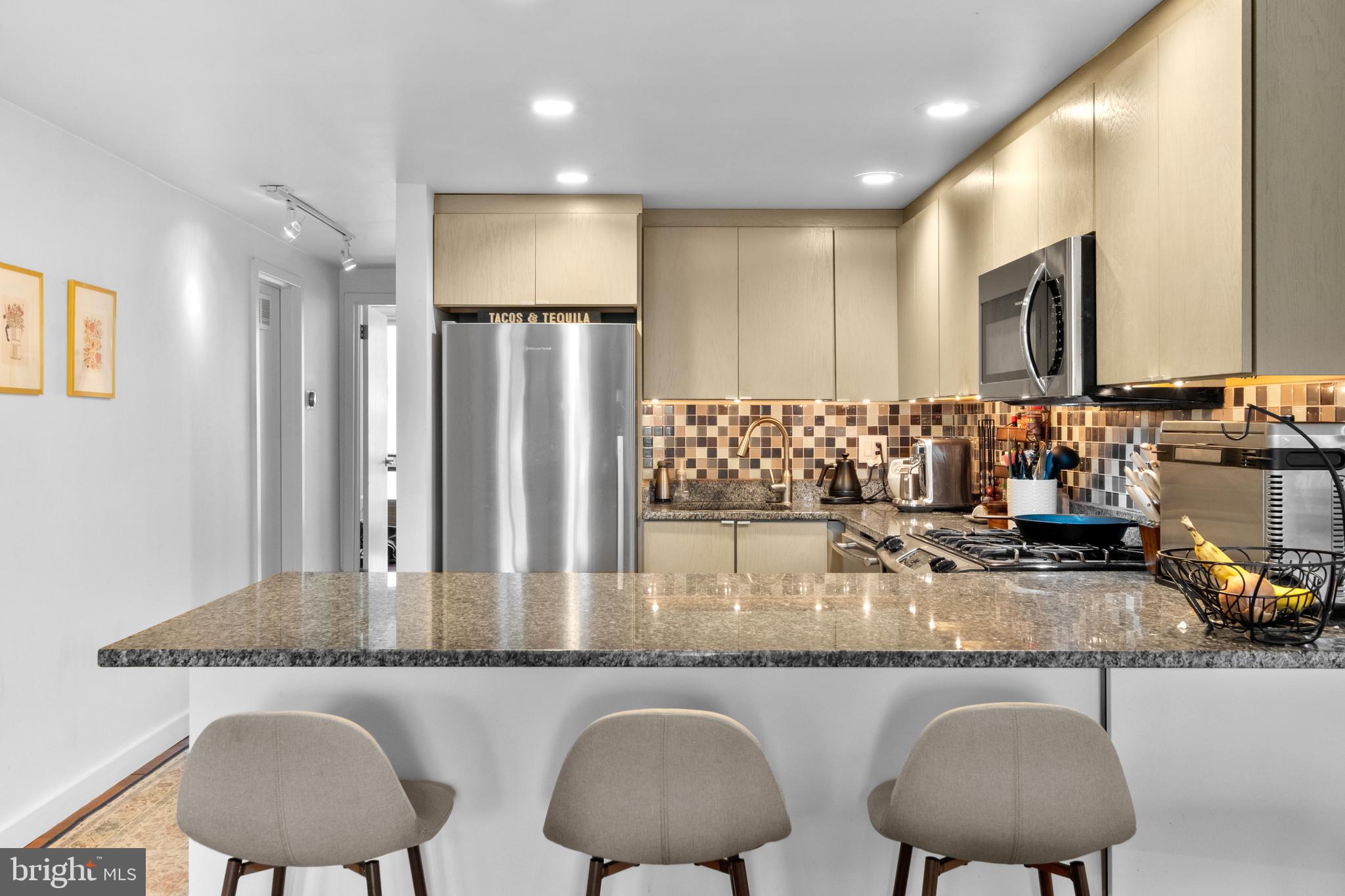 256 South 3rd Street Philadelphia, PA 19106 - Photo 55 of 72 a kitchen with stainless steel appliances granite countertop a table chairs sink and cabinet