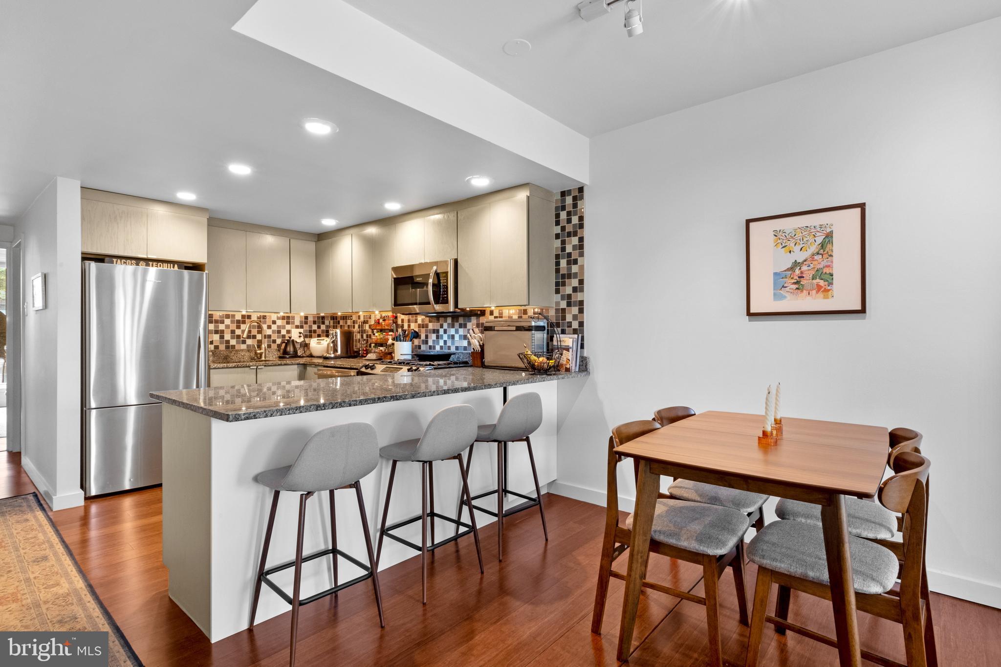 256 South 3rd Street Philadelphia, PA 19106 - Photo 56 of 72 a kitchen with stainless steel appliances kitchen island granite countertop a dining table chairs and refrigerator