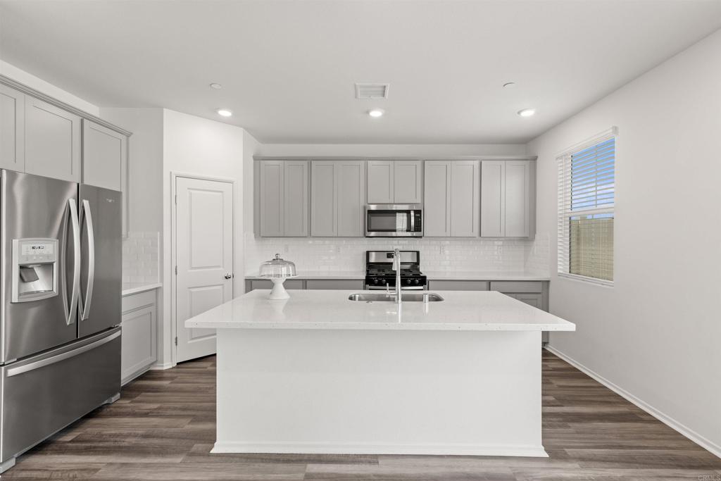 895 Brookdale Drive Vista, CA 92081 - Photo 13 of 45 a kitchen with kitchen island a counter top space a sink stainless steel appliances and cabinets