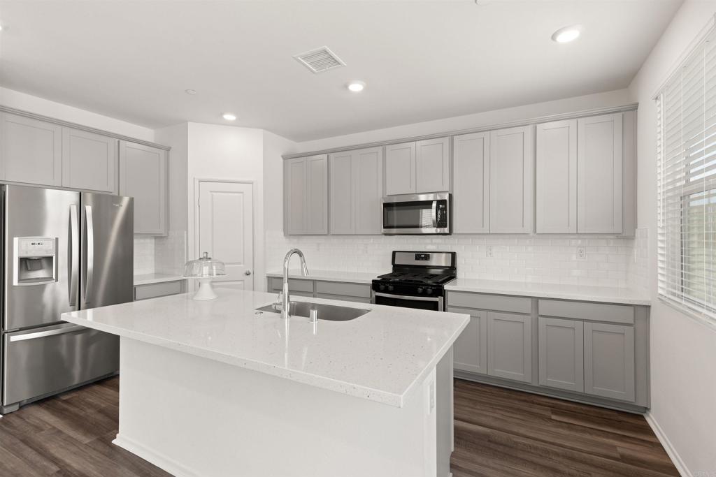 895 Brookdale Drive Vista, CA 92081 - Photo 15 of 45 a kitchen with sink a microwave and refrigerator