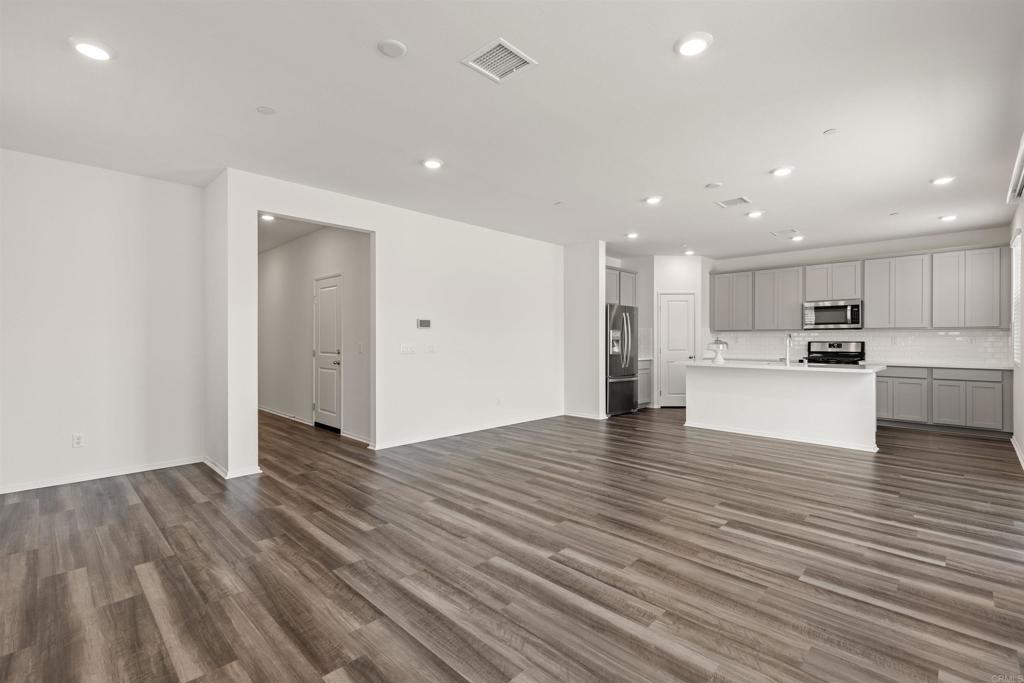 895 Brookdale Drive Vista, CA 92081 - Photo 10 of 45 a view of kitchen island wooden floor center island and stainless steel appliances
