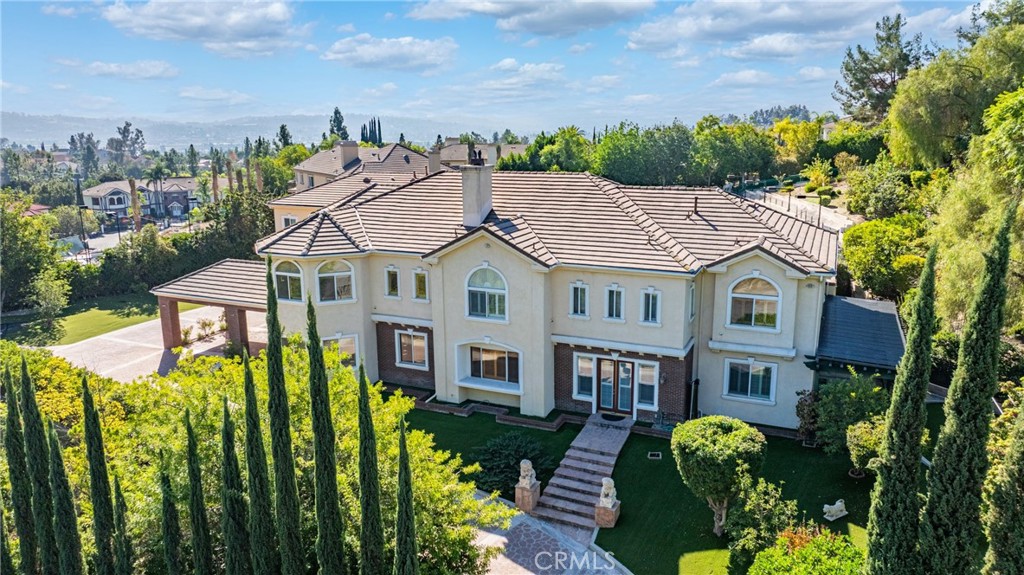 a aerial view of a house with swimming pool lawn chairs and a fire pit