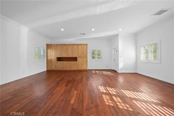 a view of a white house with a big yard and potted plants