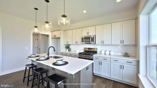 a kitchen with stainless steel appliances kitchen island granite countertop a sink a stove a dining table and chairs