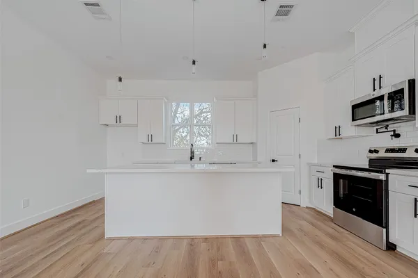 a kitchen with stainless steel appliances a white stove top oven sink and cabinets