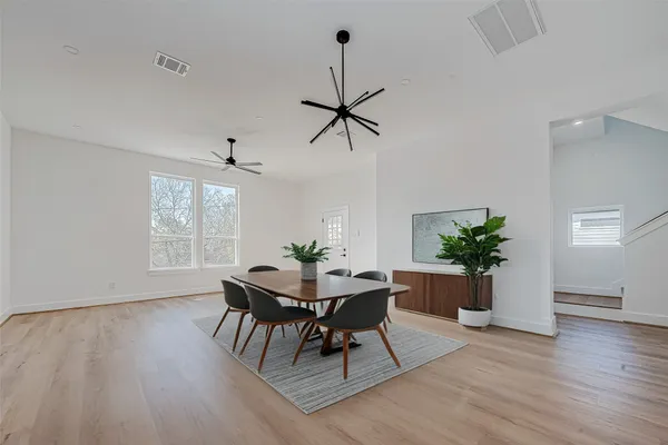 a dining room with furniture potted plants and wooden floor
