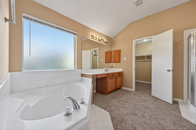 a bathroom with a tub sink and mirror