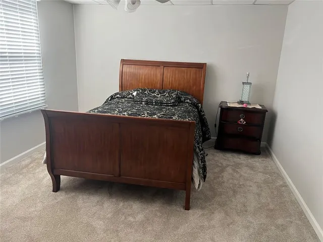 a bed sitting in a bedroom next to a window