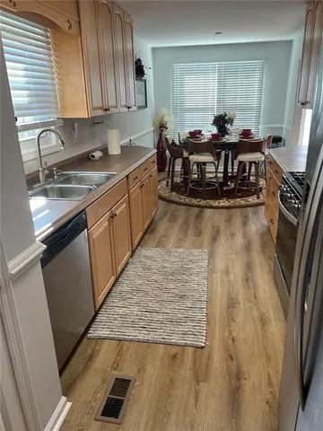 a living room with stainless steel appliances granite countertop furniture wooden floor and window