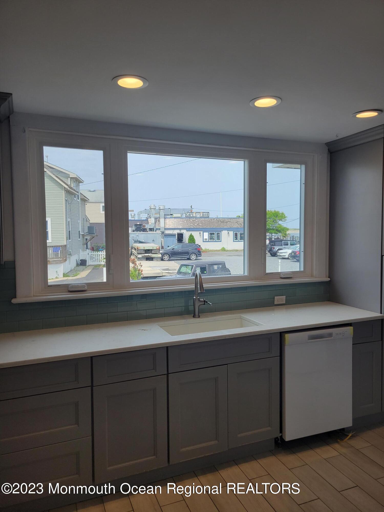 16 Cornwall Street Highlands, NJ 07732 - Photo 12 of 19 a kitchen with stainless steel appliances granite countertop a sink a window and cabinets