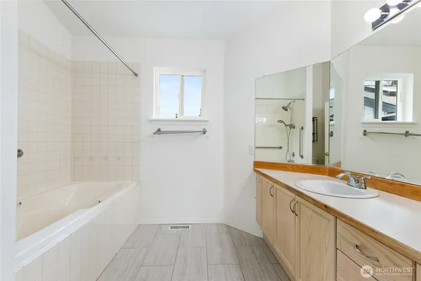 a bathroom with a tub sink and mirror