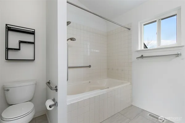 a white toilet sitting next to a bath tub