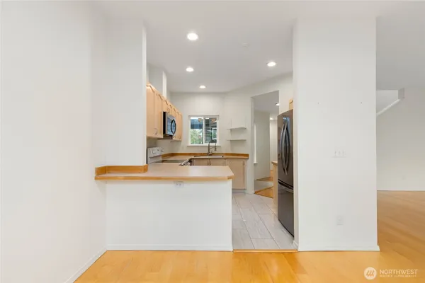 a kitchen with stainless steel appliances granite countertop a sink and a refrigerator