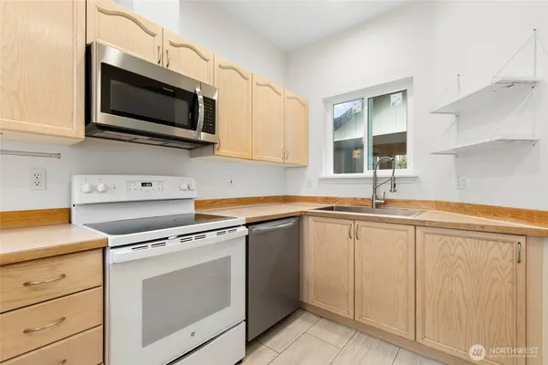 a kitchen with cabinets stainless steel appliances and a sink