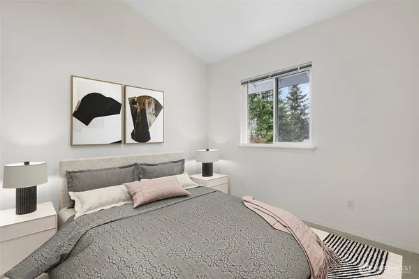 a bedroom with a bed and a painting on the wall