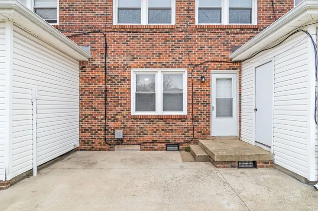 a backyard of a house with large window and brick walls