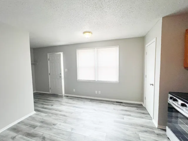 an empty room with windows and closet