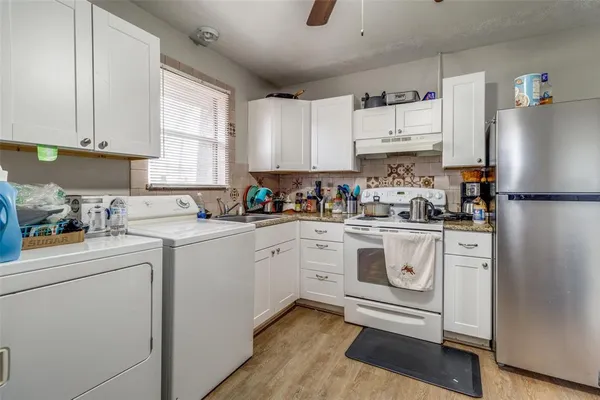 a kitchen with white cabinets and white appliances