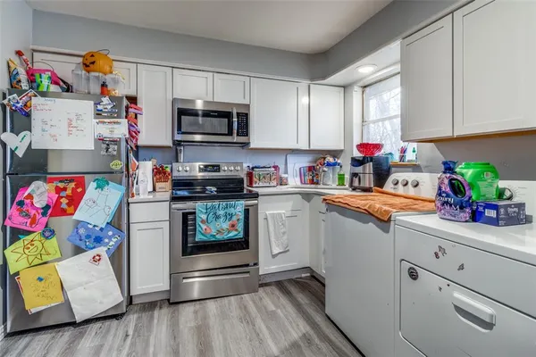 a kitchen with stainless steel appliances white cabinets and a refrigerator