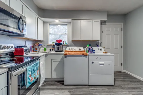 a utility room with cabinets washer and dryer