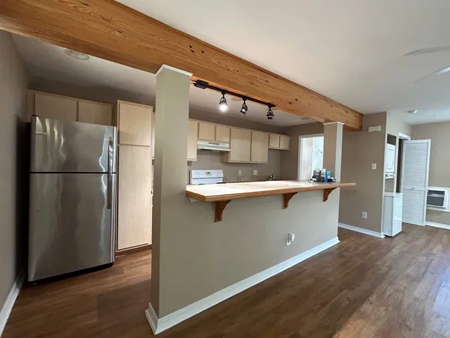 a kitchen with stainless steel appliances granite countertop a refrigerator a sink and a stove