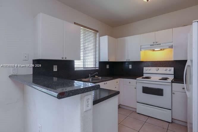 2911 Southeast 15th Road, Unit 65 Homestead, FL 33035 - Photo 5 of 11 a kitchen with granite countertop a sink a stove and cabinets