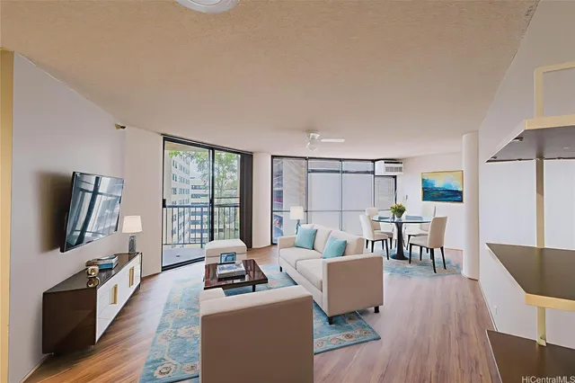 a living room with furniture a flat screen tv and wooden floor