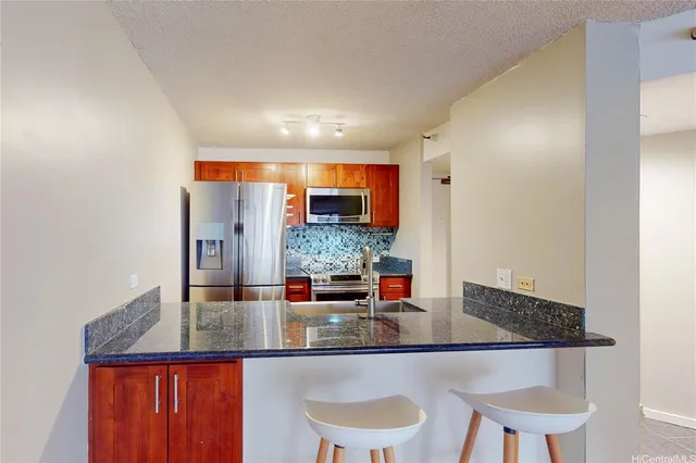 a kitchen with granite countertop a table and chairs in it