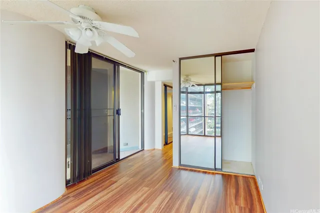 a view of a hallway with wooden floor and cabinet