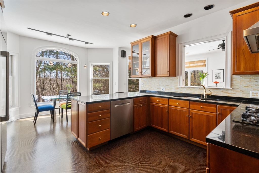 86 Whittier Road Wellesley, MA 02481 - Photo 11 of 39 a kitchen with stainless steel appliances granite countertop a sink stove and wooden cabinets