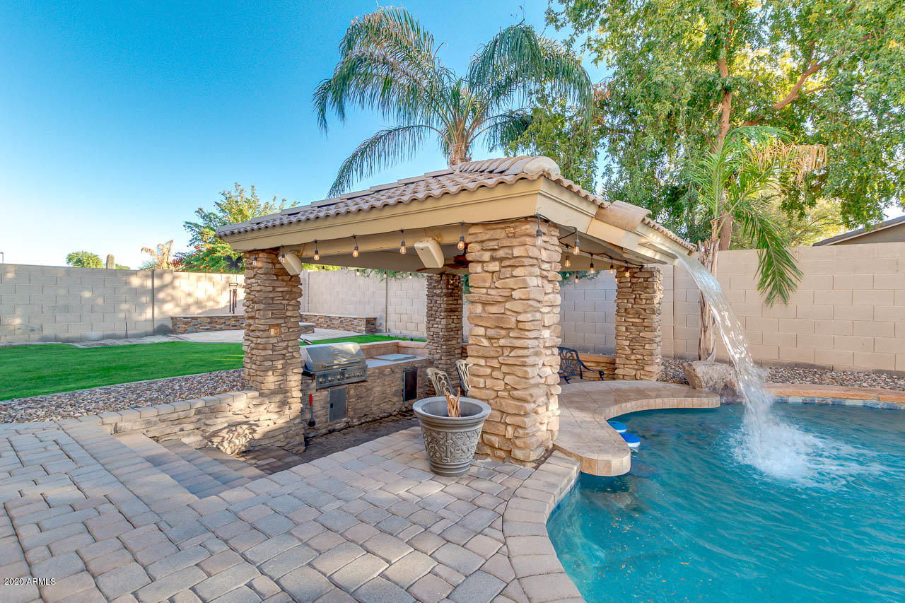 3315 East Los Altos Road Gilbert, AZ 85297 - Photo 54 of 66 a view of a patio with table and chairs potted plants and wooden fence