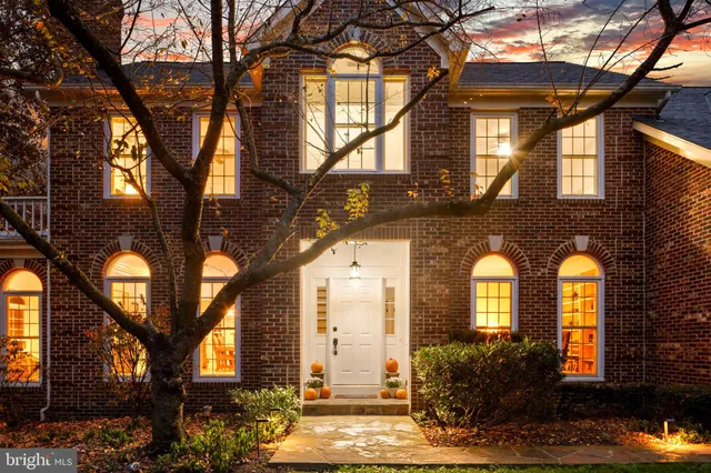 a dining room with furniture a chandelier and wooden floor