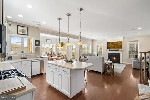 a kitchen with stainless steel appliances granite countertop a stove a sink dishwasher and a refrigerator with wooden floor