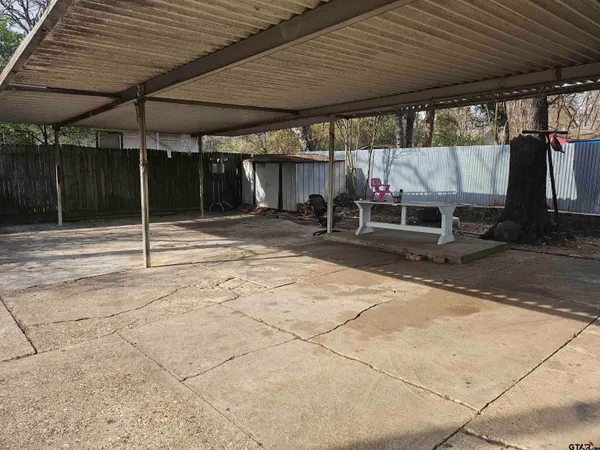a view of a patio with table and chairs under an umbrella