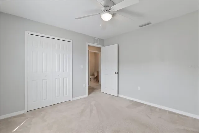 an empty room with a ceiling fan and a window