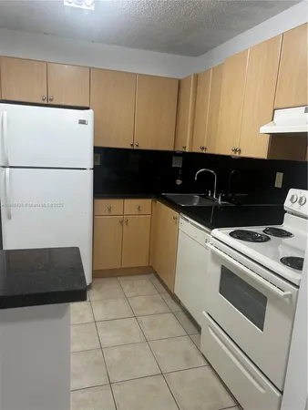 a kitchen with a sink and a refrigerator