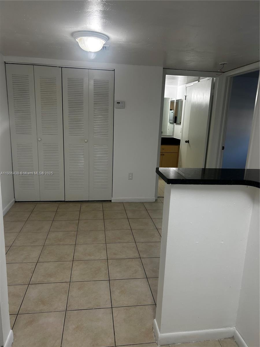 7110 Northwest 179th Street, Unit 110 Hialeah, FL 33015 - Photo 6 of 13 a view of a refrigerator in kitchen and an empty room
