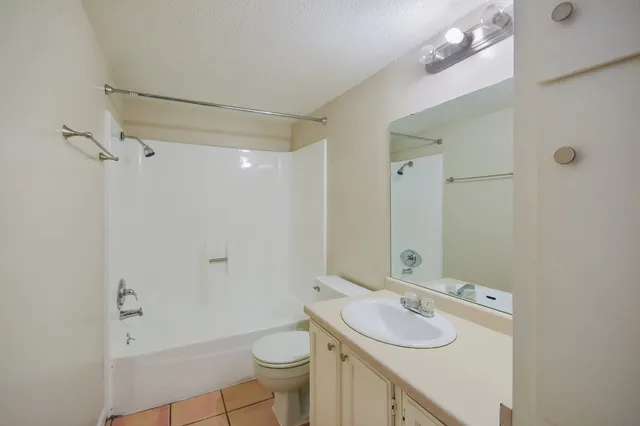 a bathroom with a sink toilet granite vanity and shower