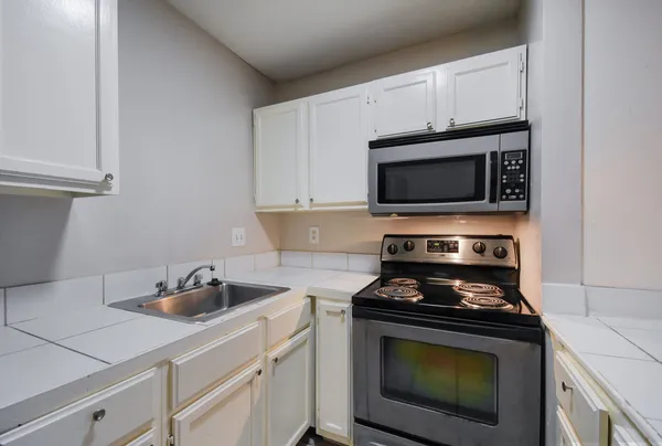 a kitchen with cabinets stainless steel appliances and a sink