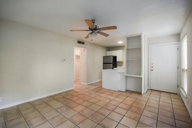 a view of a kitchen with a refrigerator and a stove top oven
