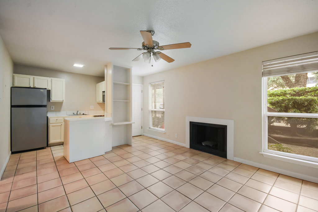 1000 West 26th Street, Unit 102 Austin, TX 78705 - Photo 9 of 23 a kitchen with a refrigerator a stove top oven and a window