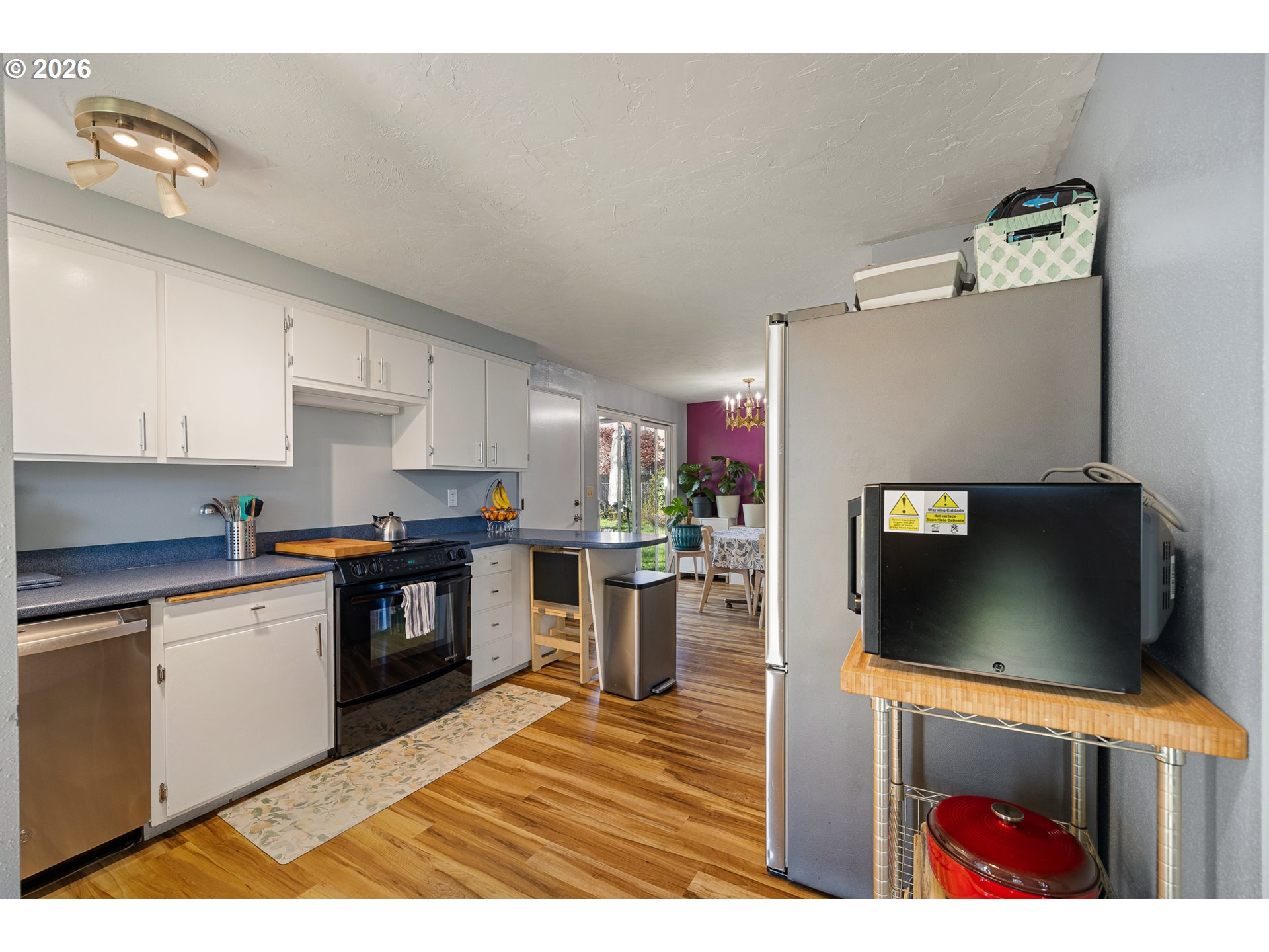 992 Candlelight Drive Eugene, OR 97402 - Photo 9 of 35 a kitchen with stainless steel appliances kitchen island granite countertop a refrigerator and microwave