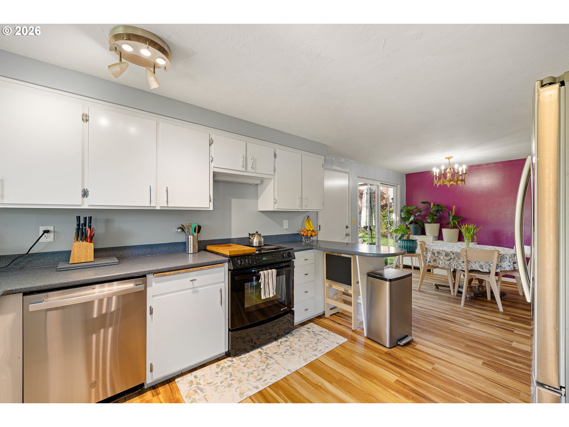 992 Candlelight Drive Eugene, OR 97402 - Photo 10 of 35 a kitchen with stainless steel appliances granite countertop a stove a sink dishwasher and cabinets with wooden floor