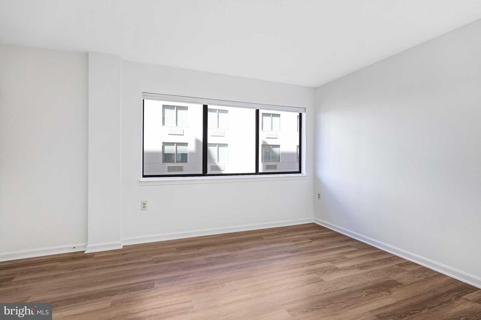 1301 North Courthouse Road, Unit 705 Arlington, VA 22201 - Photo 11 of 38 a view of an empty room with wooden floor and a window