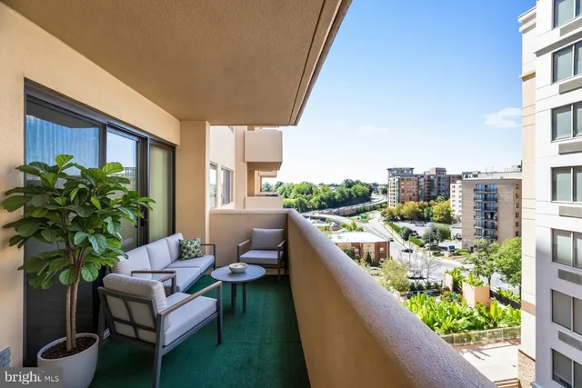 a view of a balcony with chairs and a potted plant