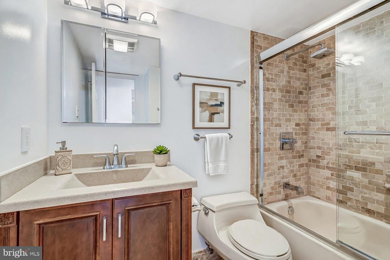 1301 North Courthouse Road, Unit 705 Arlington, VA 22201 - Photo 9 of 38 a bathroom with a sink toilet a mirror and shower
