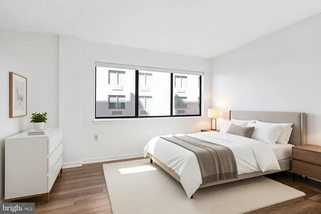 a bedroom with a bed and a large window