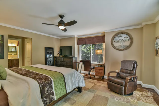 a spacious bedroom with a bed a couch and a chandelier